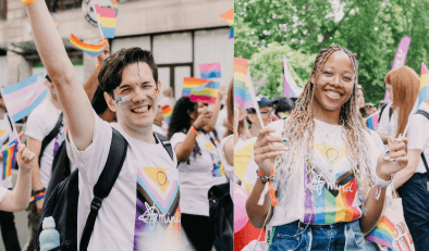 Man and woman smiling and holding Rainbow flags